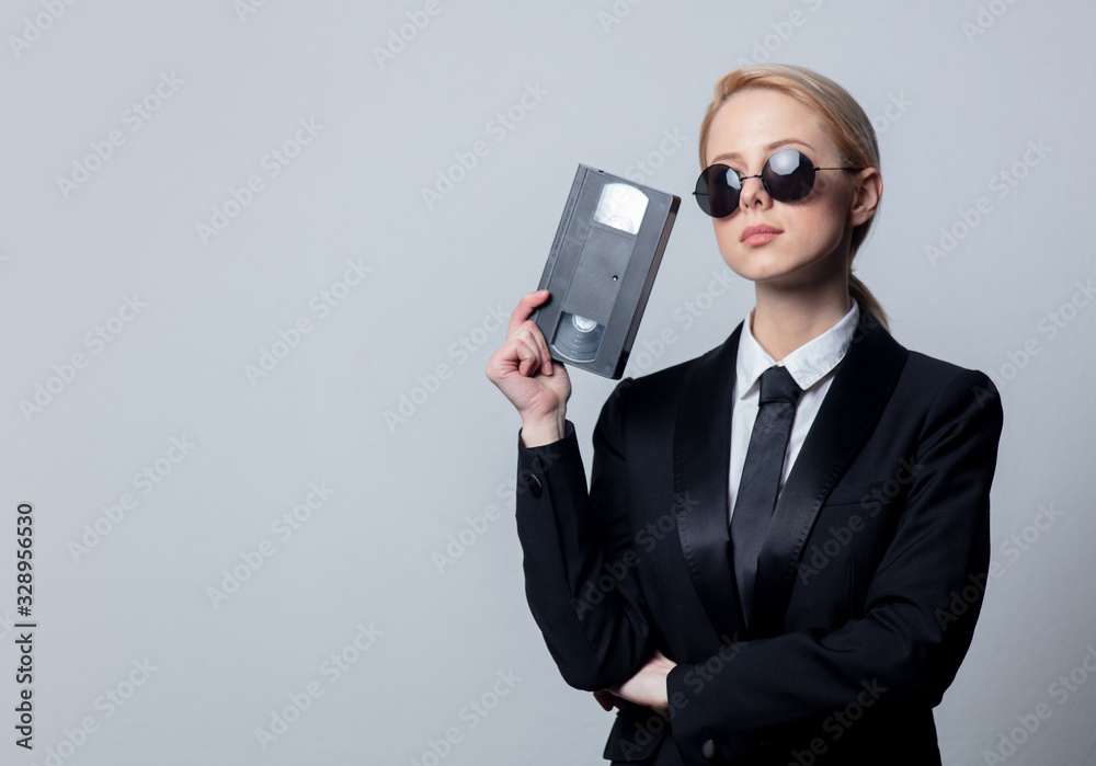 businesswoman in sunglasses with video tape - obrazy, fototapety, plakaty 