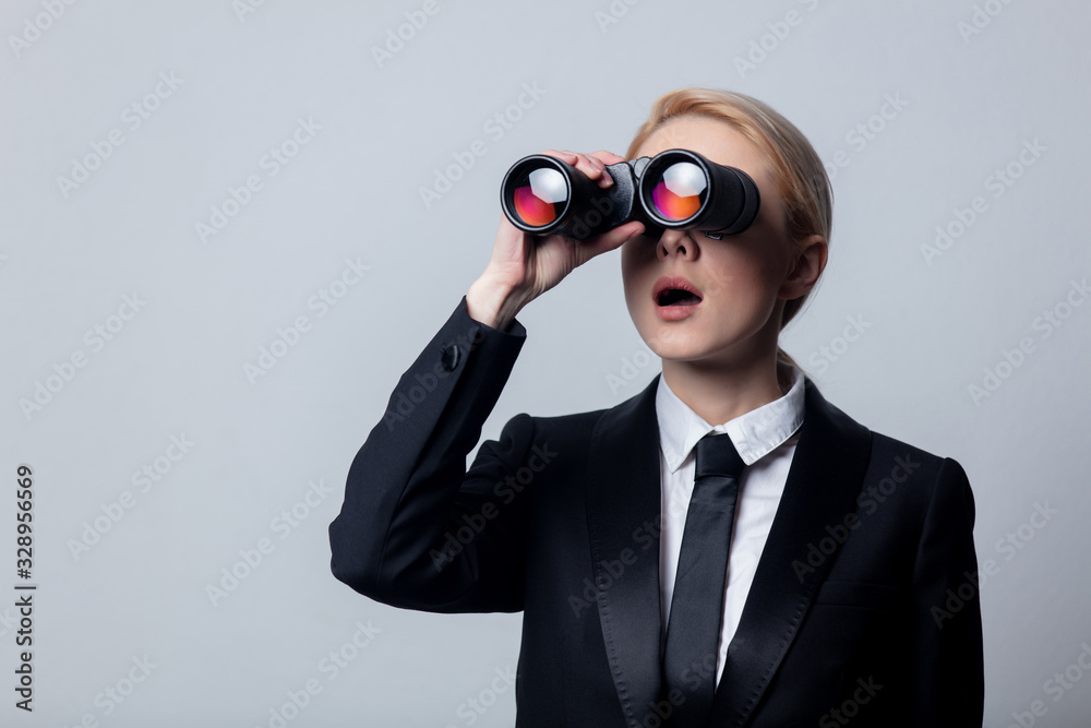 businesswoman in a classic black business suit with binoculars businesswoman in a classic black business suit with binoculars