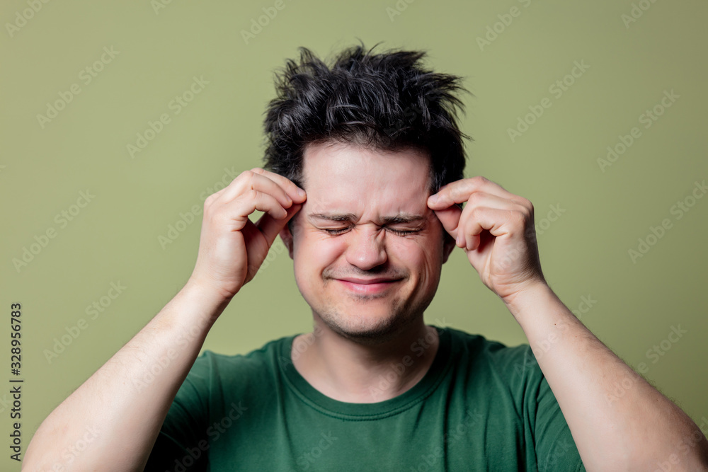 Man in green shirt with headache