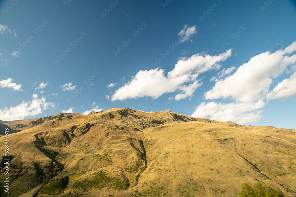 Rolling mountain and sky with cottony clouds