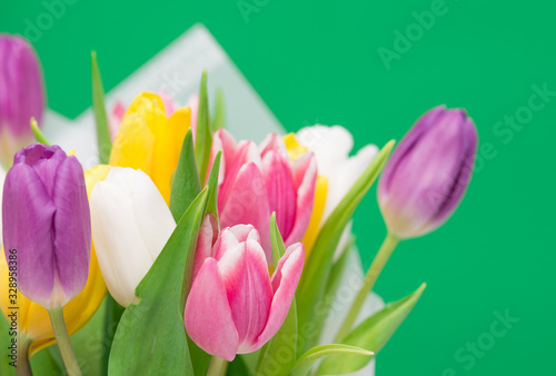Fototapeta Naklejka Na Ścianę i Meble -  Bouquet of colored tulips on green background. spring bouquet. copy space