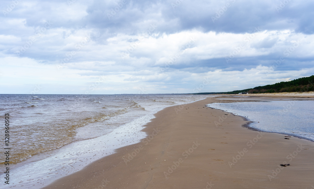 Clouds on a cloudy sky over the sandy beach of the Baltic Sea in Jurmala