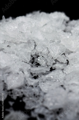 Maldon salt on black background macrophotography with slight defocus. Purity.