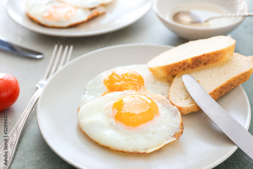 Plate with fried eggs and bread on table Plate with fried eggs and bread on table