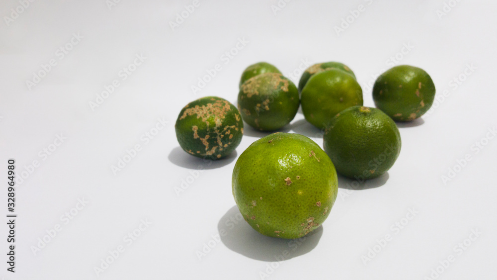 Limão verde, destacado em primeiro plano e grupo de limões desfocado ao fundo. Limão verde, destacado em primeiro plano e grupo de limões desfocado ao fundo.