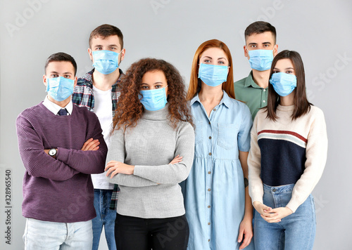 Group of people with protective masks on grey background. Concept of epidemic