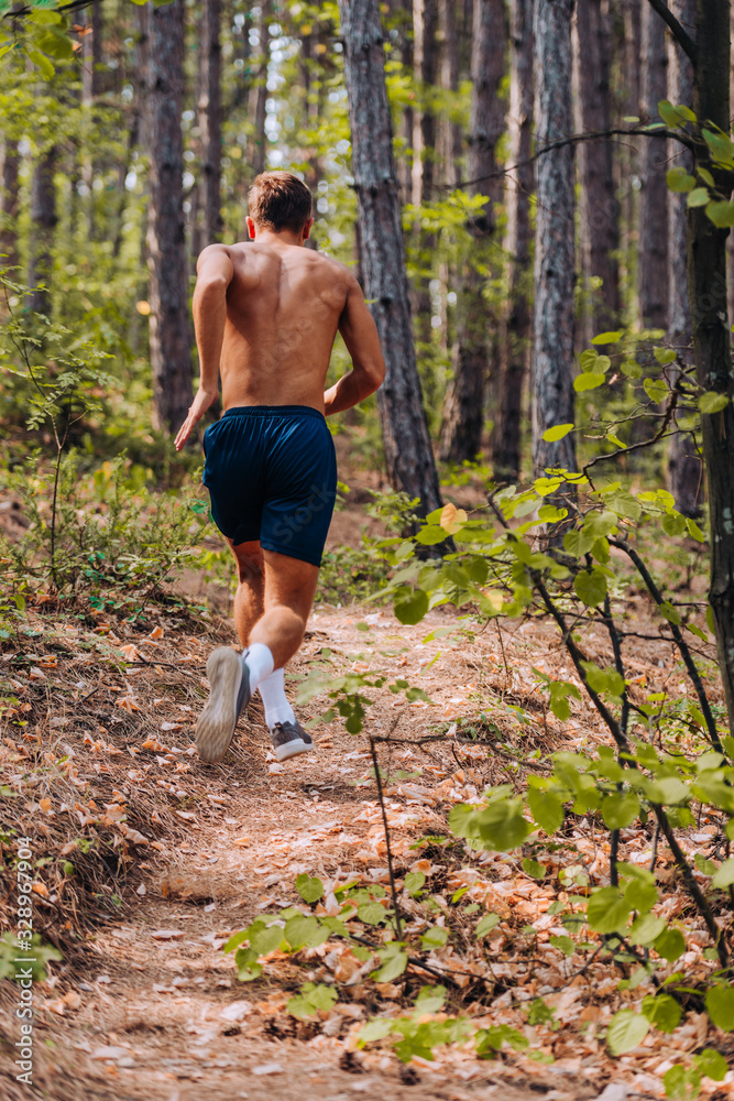 Male runner in sunset rise against beautiful nature at the mountain Male runner in sunset rise against beautiful nature at the mountain