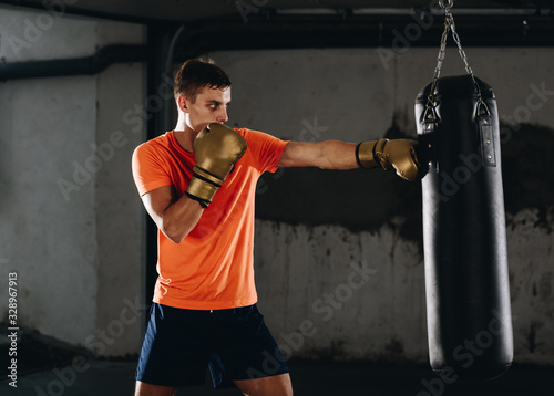 Kickboxer training in the garage kicking the punch bag