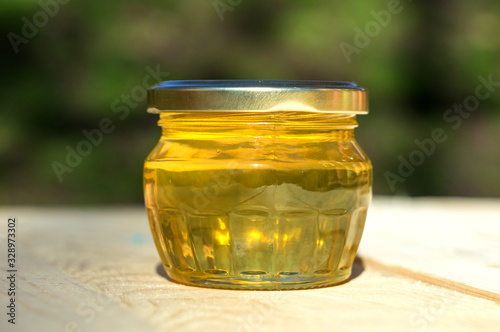 small glass jar of honey on a wooden table