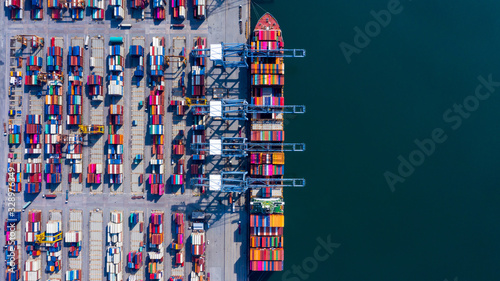 Obraz na plátně Aerial view container cargo ship freight shipping unloading at original destination port with quay crane, Business commercial global oversea logistic import export container box by container vessel