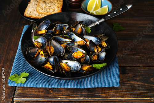 Delicious steamed mussels with spices, green onion, and parsley photo