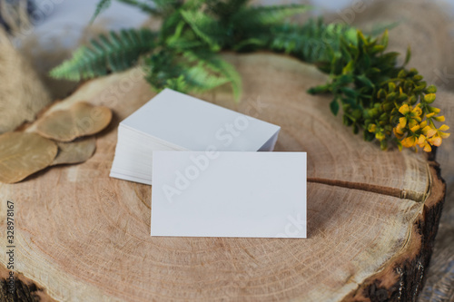 Business cardmock up on wooden table with plants. Business card stack template. Corporate stationery set. Business card mockup on rustic composition. Top and front view.