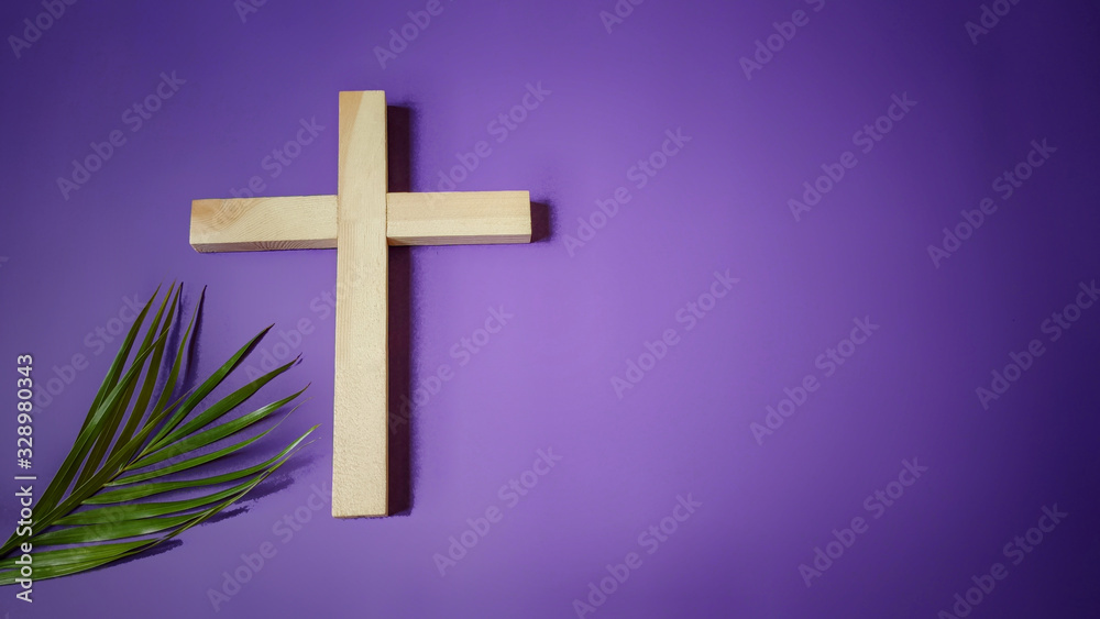 Lent, Holy Week concept - cross and palm leaf on a purple vintage background.