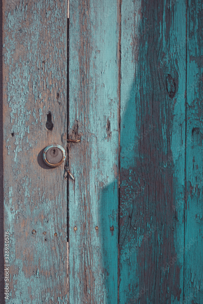 Wooden door with peeling paint and vintage handles with space for text