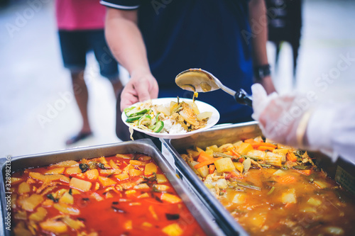The donor gives warm food to the poor, concept of sharing food to the poor