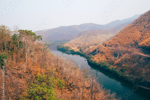 Beautiful natural scenery of river in southeast Asia tropical green and brown forest with mountains in background. river at phumiphol dam Thailand