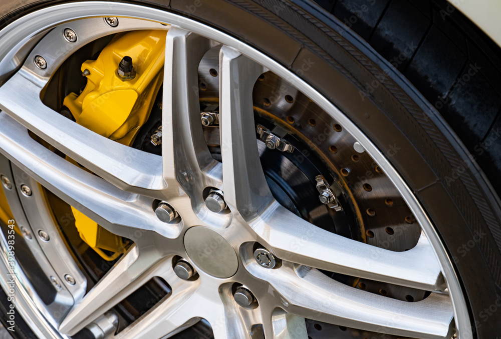 Automobile braking system. Ceramic carbon disk with perforation, ventilation and black calipers.