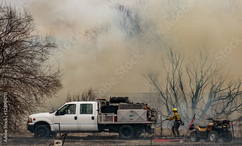 Female Firefighter Pulls Hose off Brush Engine