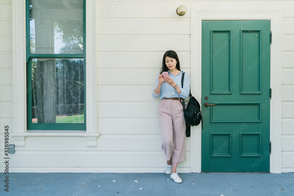 woman using phone texting standing on street woman using phone texting standing on street
