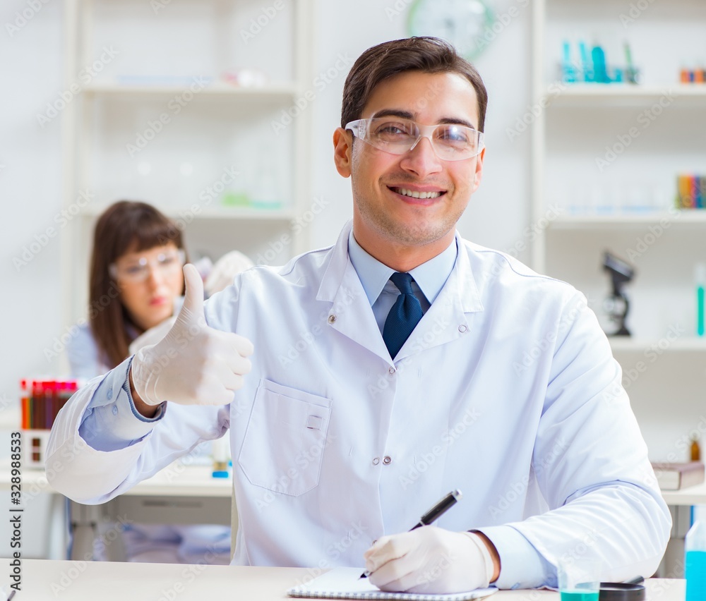 Two chemists working in lab experimenting Two chemists working in lab experimenting