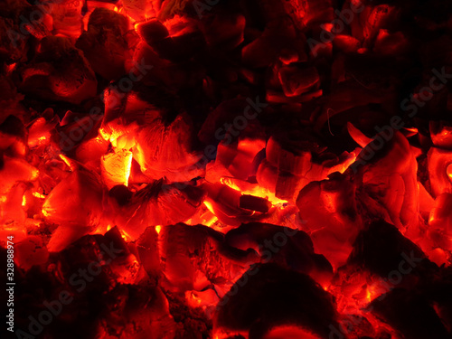 Burning coals in the fire. Red flaming coals from burning wood. Coals in the heating furnace. The fiery background.