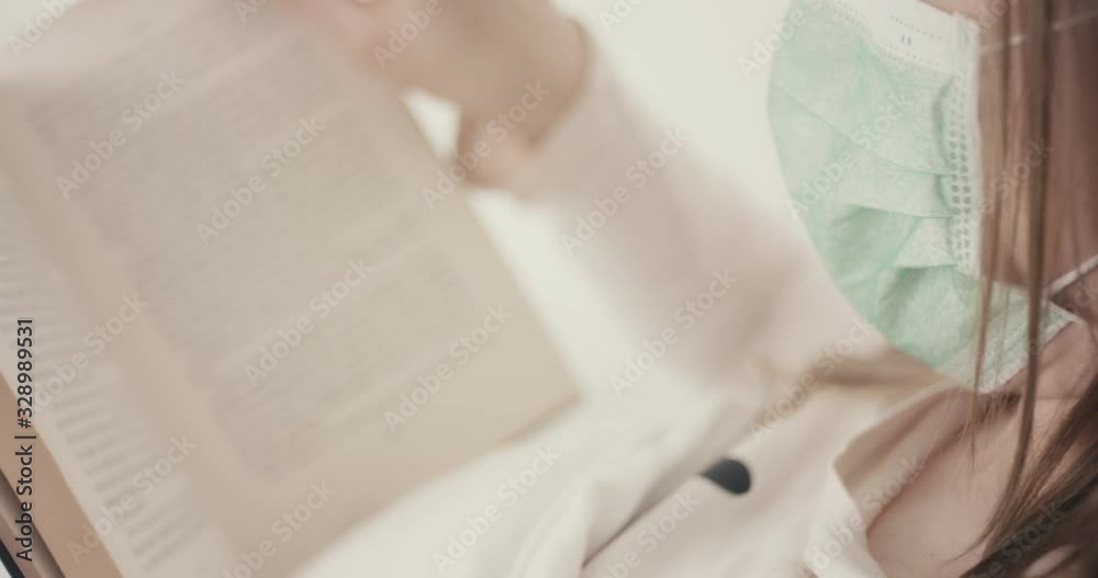 Woman with face mask reading a book coughing in bed protection virus coronavirus quarantine unrecognizable Woman with face mask reading a book coughing in bed protection virus coronavirus quarantine unrecognizable