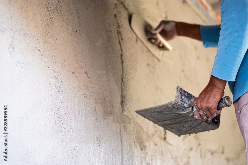 Construction workers are plastering the cement for building walls with plastering tools. Construction workers are plastering the cement for building walls with plastering tools.