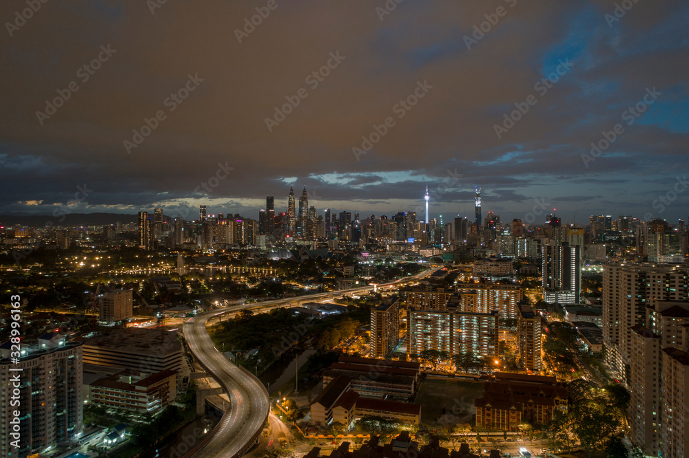 Fototapeta premium Aerial Panoramic view of Kuala Lumpur with rain clouds during night time.