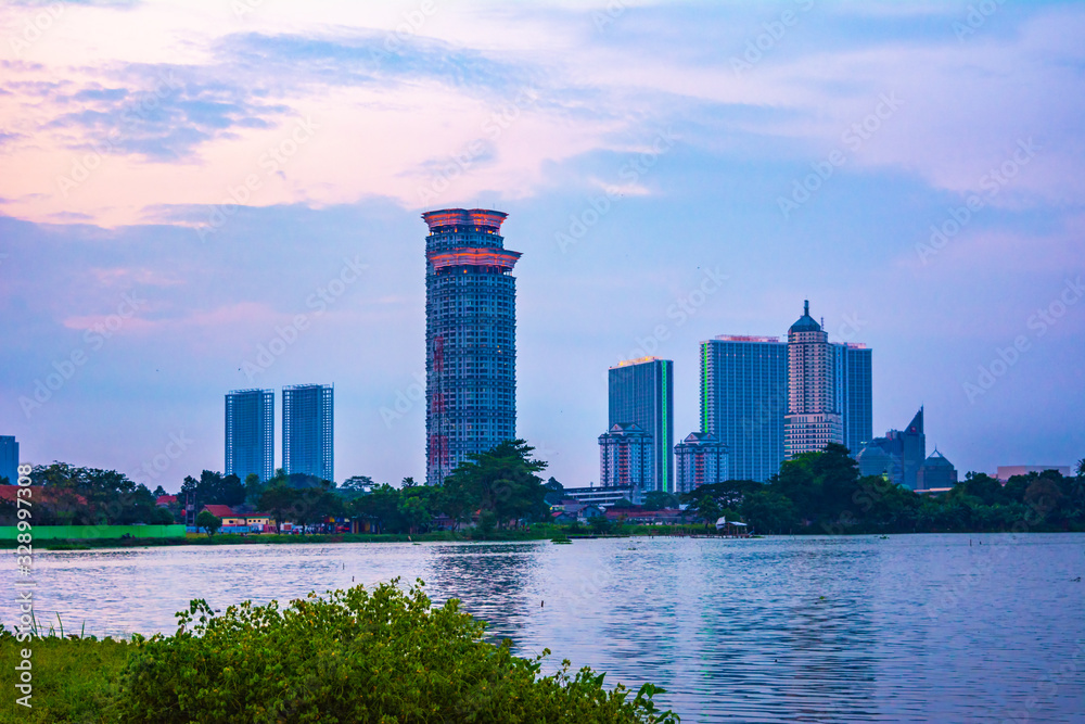 Fototapeta premium Tangerang, Indonesia - 5th January 2018: A view of Danau Kelapa Dua (Kelapa Dua Lake) on the foreground and Lippo Karawaci district buildings in the background. Taken in a cloudy afternoon.