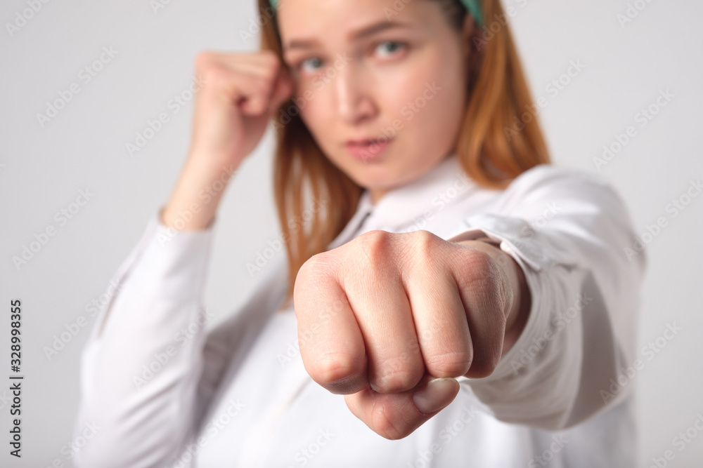 Girl power concept. Confident young woman isolated on gray wall background. Feminine and independent strength.Girl strikes. Girl power concept. Confident young woman isolated on gray wall background. Feminine and independent strength.Girl strikes.
