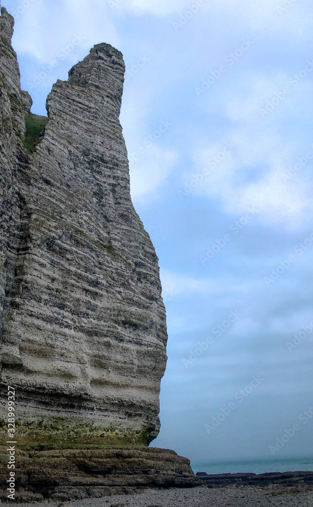 The needle in the chalk cliffs of the Normandy coast of Etretat, France, on a grey misty day