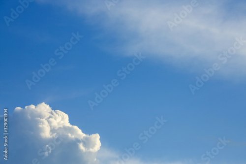 sunlight through fluffy white cloud on clear blue sky background