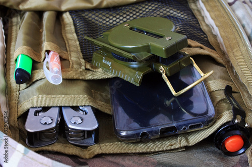 Phone, compass and flashlight in a backpack