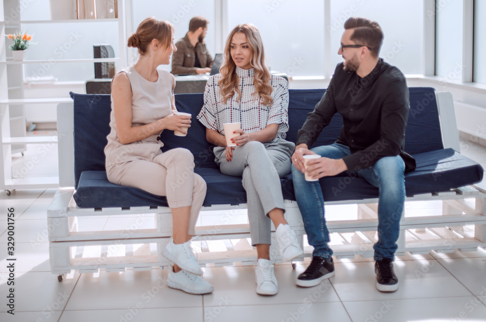 business team is discussing something sitting in the office lobby business team is discussing something sitting in the office lobby