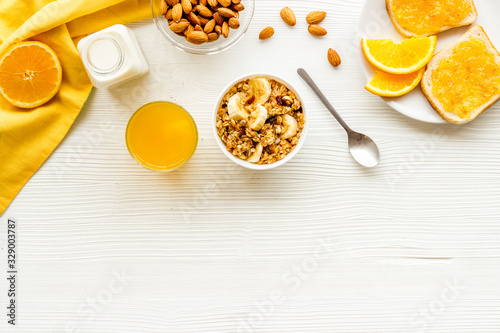 Homemade granola for morning meal. White desk with taost and fruits top-down frame copy space