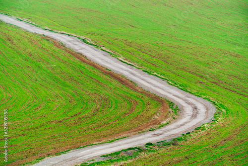 Winding dirt road in farm field