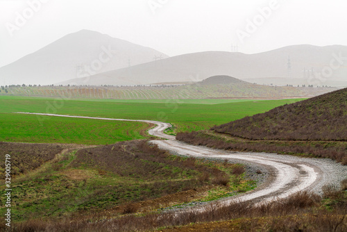 Winding dirt road in farm field