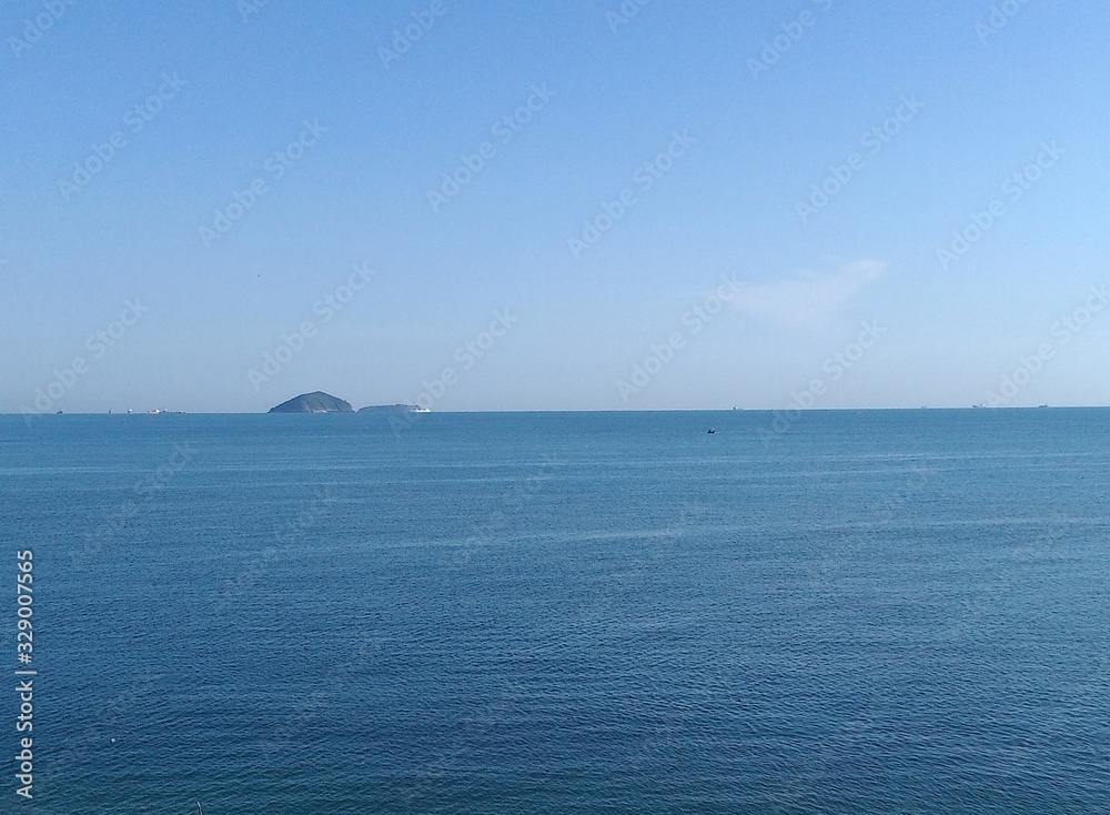 The beautiful blue sea with island and background clear sky, feeling relaxed, free space for texts. Concept Clear blue sky and sea. background