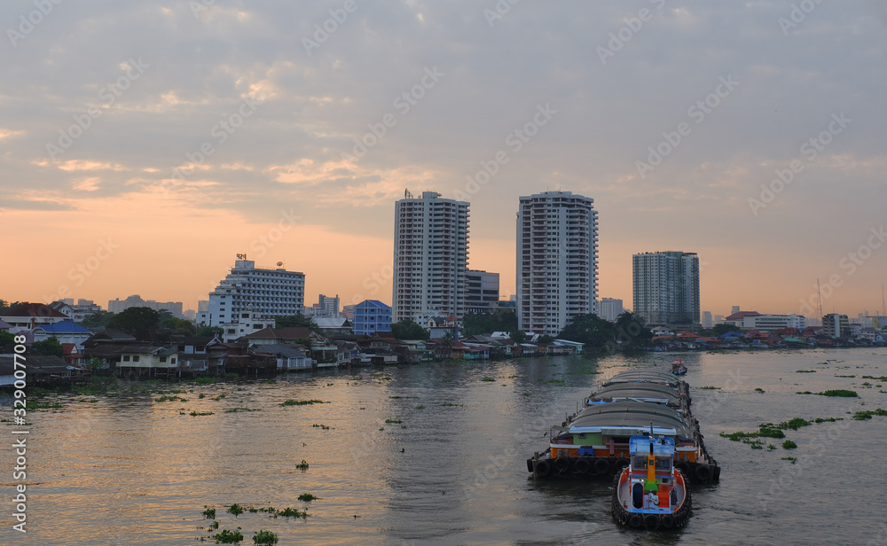 Sunrise view of Chao Phraya River from Rama 5 bridge, Bangkok, Thailand . Shows water transport.