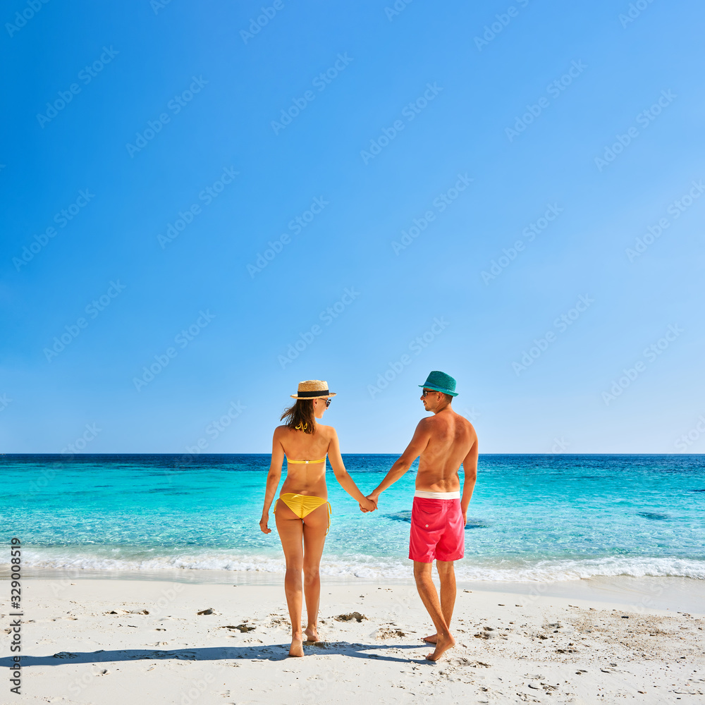 Couple walking on a tropical beach Couple walking on a tropical beach
