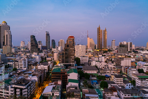 Aerial cityscape of picturesque Bangkok at sunset from rooftop view. Panoramic sunrise skyline of the biggest city in Thailand. The concept of metropolis.