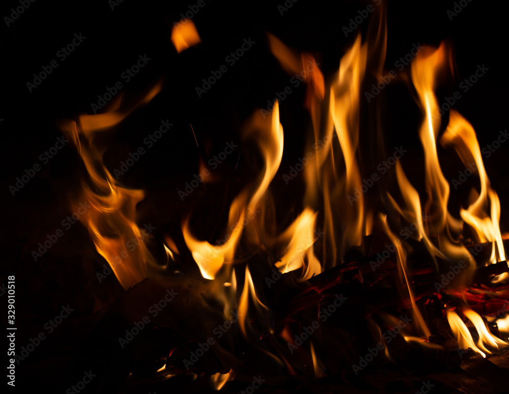 Fire flame caused by burning of wood on a black background Fire flame caused by burning of wood on a black background