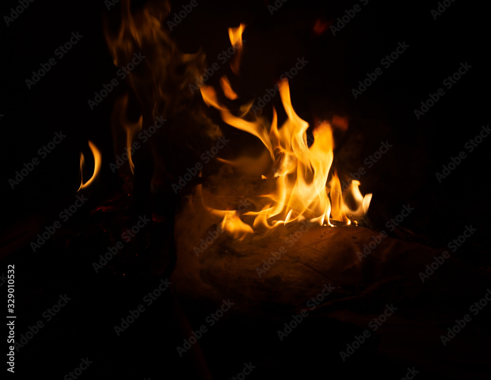 Fire flame caused by burning of wood on a black background Fire flame caused by burning of wood on a black background