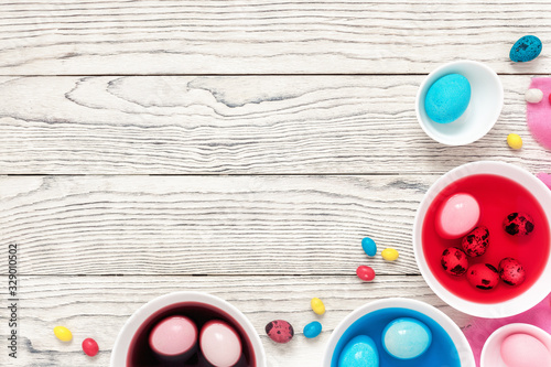 Easter eggs dyeing in bowls with colors at home. Top view, flat lay, copy space