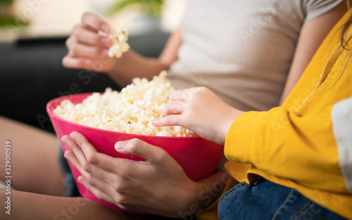 Close Up Two Girls Eating Pop Corn From Pink Bowl