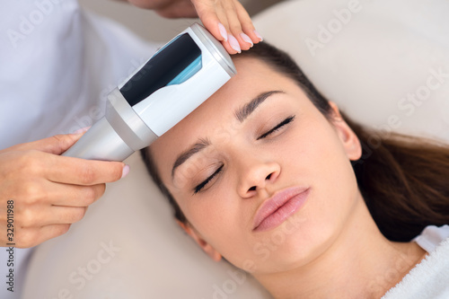 Close up of young woman enjoying ultrasound facial massage