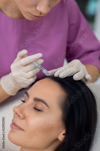 Beauty doctor wearing white gloves making mesotherapy
