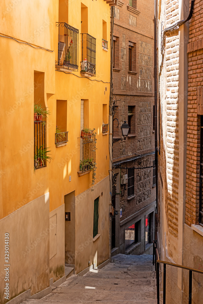Narrow cobblestone medieval street in Toledo city. Spain