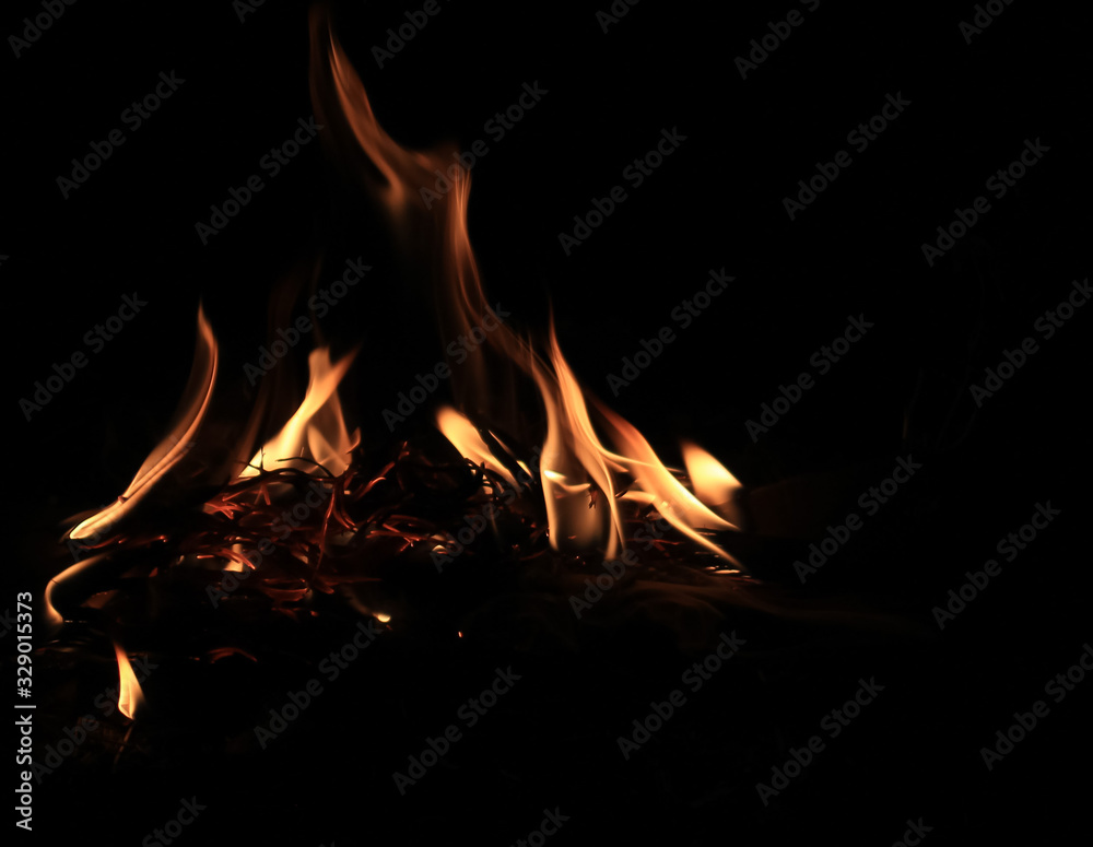 Fire flame caused by burning of wood on a black background Fire flame caused by burning of wood on a black background