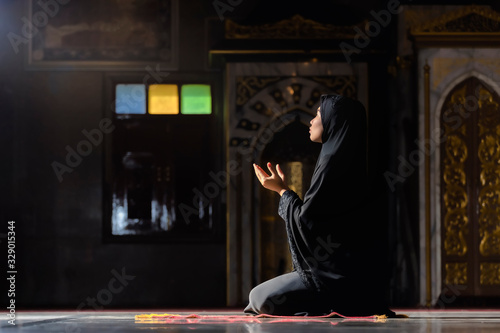 Muslim women wearing black shirts Doing prayer According to the principles of Islam.
